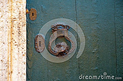 Part of an old wooden door with an iron handle and keyholes Stock Photo