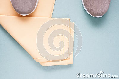 Part of pair of sneakers and sports yellow pants on a green background with copy space. Stock Photo