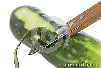 Cucumber being peeled with a wooden peeler and a Bark from peeled cucumber on white Stock Photo