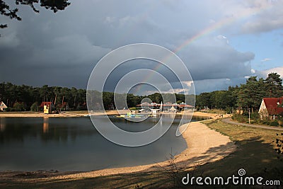 Part of Rainbow above lake of recreation area Landgoed `t Loo in the Netherlands. Stock Photo