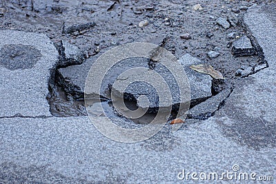 Part of the road with pieces of gray broken asphalt Stock Photo