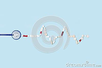 Part of a stethoscope and a electrocardiogram made with medical pills and capsules Stock Photo