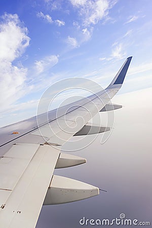 Traveling by plane. View from the window to the clouds and blue sky. Stock Photo