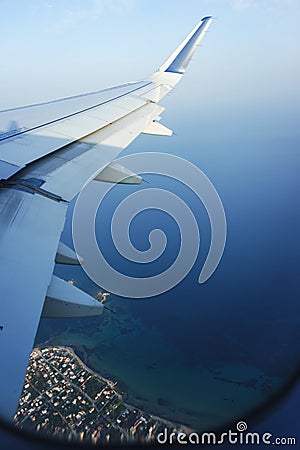 Traveling by plane. View from the window to the sea and blue sky. Stock Photo