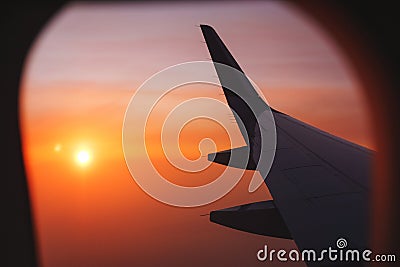 Traveling by plane. View from the window to the clouds and dawn. Stock Photo