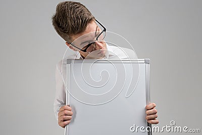 Part of young man wearing glasses with clean magnetic Board in his hands isolated on white background Stock Photo
