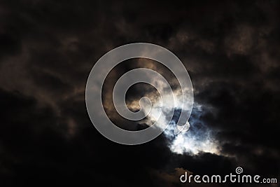 A partial solar eclipse of October 25, 2022 captured through moody dark clouds, the maximal phase visible from Europe Stock Photo