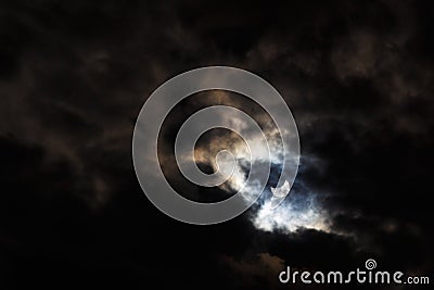 A partial solar eclipse of October 25, 2022 captured through moody dark clouds, the maximal phase visible from Europe Stock Photo