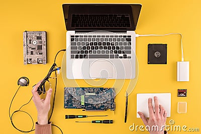 partial top view of person holding eyeglasses and fixing laptop Stock Photo
