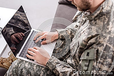 partial view of army soldier using laptop Stock Photo