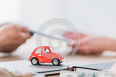 View of businessman and customer near red toy car in office Stock Photo