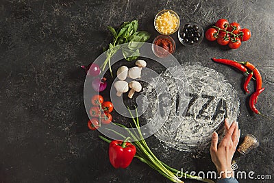 partial view of female hand, fresh ingredients and pizza lettering made of flour Stock Photo