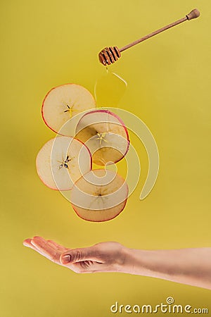 partial view of female hand and levitating pieces of apple Stock Photo