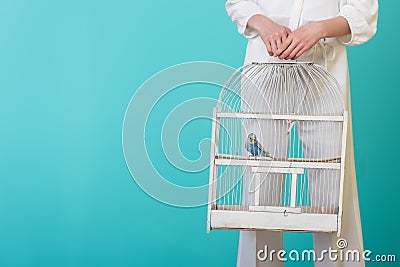 partial view of girl in white with parrot in white cage, Stock Photo