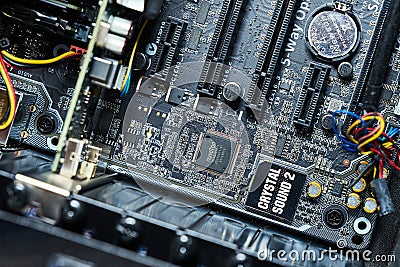 Partial view of the motherboard of a computer with the sound chip and the battery for the internal clock of the motherboard Editorial Stock Photo