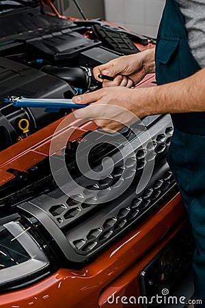 partial view of repairman with notepad examining car Stock Photo