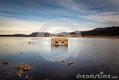 Abandoned and partially submerged stone building in lake in Corsica Stock Photo