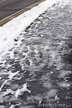 Partially thawed snow on pavement Stock Photo