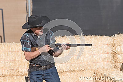 Participant dressed in period cowboy costume, portraying gunfig Editorial Stock Photo