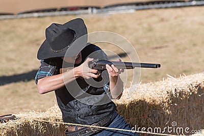 Participant dressed in period cowboy costume, portraying gunfig Editorial Stock Photo