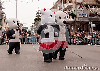 Participants dressed in large inflatable suits are walking along Editorial Stock Photo