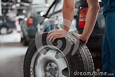 Particle view. Employee in the blue colored uniform works in the automobile salon Stock Photo