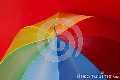 Particoloured umbrella on red background Stock Photo