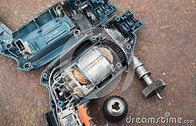 Parts of disassembled electric drill on rusted background. Stock Photo