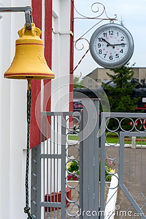 Parts of the old railway station. Retro clock and bell on the train platform Stock Photo