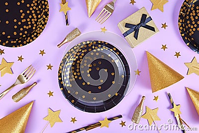 Party flat lay with black and golden plates, forks, gift, champagne bottle and star confetti Stock Photo