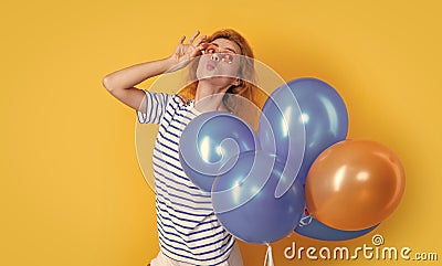 party girl with balloon in sunglasses. positive girl hold party balloons in studio. Stock Photo