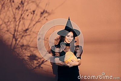 Halloween Woman in Witch Costume Holding Pumpkin Stock Photo