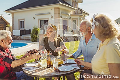 Party host serving food on a tray while having an outdoor lunch with friends Stock Photo