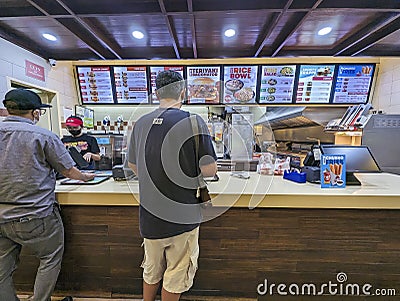 Pasay, Metro Manila, Philippines - A man orders a burger for dine-in at a Wendy's Editorial Stock Photo