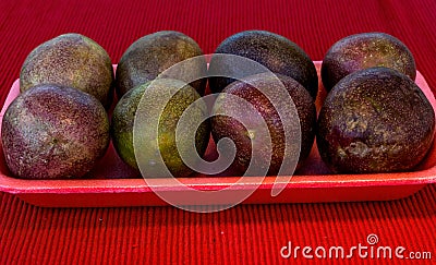 Pasiflora fruits on plastic tray on red cloth napkin Stock Photo