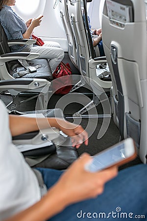Passangers in abord a commercial flight using their cell phones Stock Photo