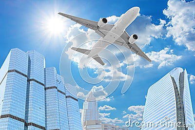 Passenger aircraft flying above high building skyscrapers Stock Photo