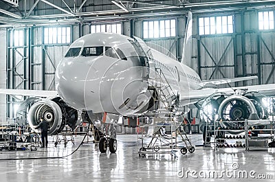 Passenger aircraft on maintenance of engine and fuselage repair in airport hangar. Editorial Stock Photo