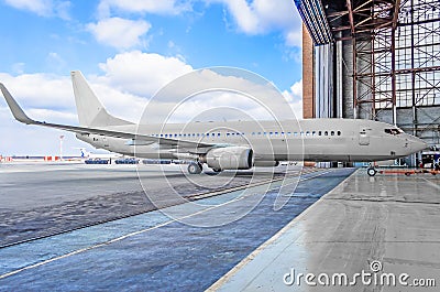 Passenger aircraft on maintenance of engine and fuselage repair in airport hangar. Stock Photo