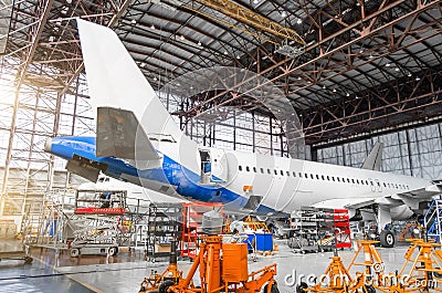 Passenger aircraft on maintenance of engine repair, among the jacks, a view of the tail and the rear of the fuselage in airport ha Editorial Stock Photo