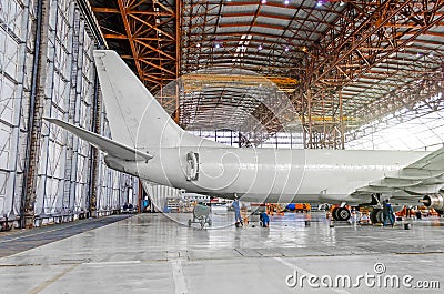 Passenger aircraft on maintenance of repair, a view of the tail and the rear of the fuselage in airport hangar. Editorial Stock Photo