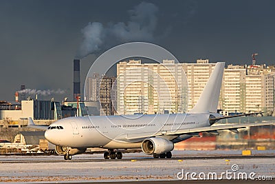 Passenger aircraft taking off at sunset in winter day. Airplane turns on runway Stock Photo