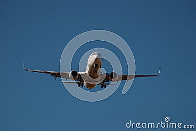 Passenger airline twin jet engine aircraft coming into land in blue sky Stock Photo