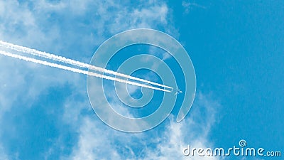 Passenger airliner flies out of the cloud. two traces of the working aircraft engines Stock Photo