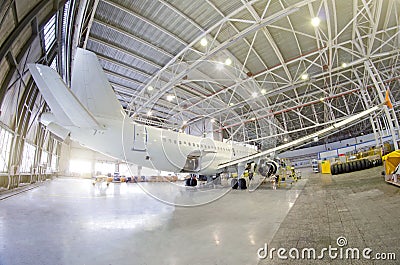 Passenger airplane on maintenance of engine, fuselage and on auxiliary power unit. check repair in airport hangar. Aircraft view t Stock Photo