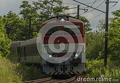 Passenger diesel red big train near Kysak station in summer hot morning Stock Photo