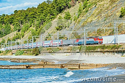 Passenger double deck train moves along Black sea coast Stock Photo