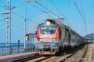 Passenger double deck train moves along the platform by the Black sea coast Stock Photo