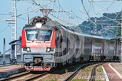 Passenger double deck train moves along the platform by Black Sea Stock Photo