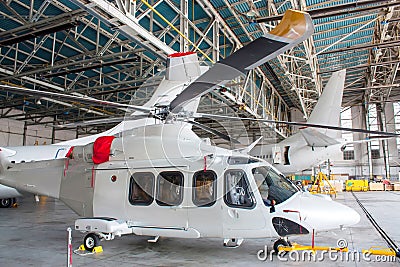 Passenger helicopter and airplanes under maintenance. Checking mechanical systems for flight operations. Rotorcraft and aircrafts Editorial Stock Photo